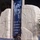 Martin Luther King Jr. float at the 57th Presidential Inauguration The image shows a large stone monument installation featuring two massive pale stone blocks flanking a vertical banner. The banner displays a black-and-white portrait photograph of a man and the quote 'Out of the Mountain of Despair a Stone of Hope.' A uniformed security guard stands at the base of the monument, with crowds and an American flag visible in the background.