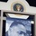 The Martin Luther King Jr. float at the 57th Presidential Inauguration The image shows a large banner or poster featuring a black-and-white close-up photograph of a man in a suit, displayed beneath the Presidential Seal of the United States. The setting appears to be an indoor exhibition or museum display. The Presidential Seal is partially visible at the top, reading 'President of the United States.'