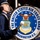 United States Air Force Band passes presidential reviewing stand A uniformed member of the United States Air Force Band is playing a bass drum during a parade in Washington, D.C. The large drum head prominently displays the official seal of the United States Air Force Band along with the text 'The United States Air Force Band, Washington D.C.' Additional band members in matching blue uniforms are visible in the background.