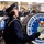 United States Air Force Band passes presidential reviewing stand Members of The United States Air Force Band from Washington D.C. are performing in a parade or ceremonial event. The foreground features a bass drummer in full dress uniform carrying a large drum emblazoned with the band's official seal and insignia. A crowd of spectators is visible in the background observing the performance.