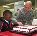 BACH commander and 5-year-old patient cut cake celebrating Patient Recognition Month