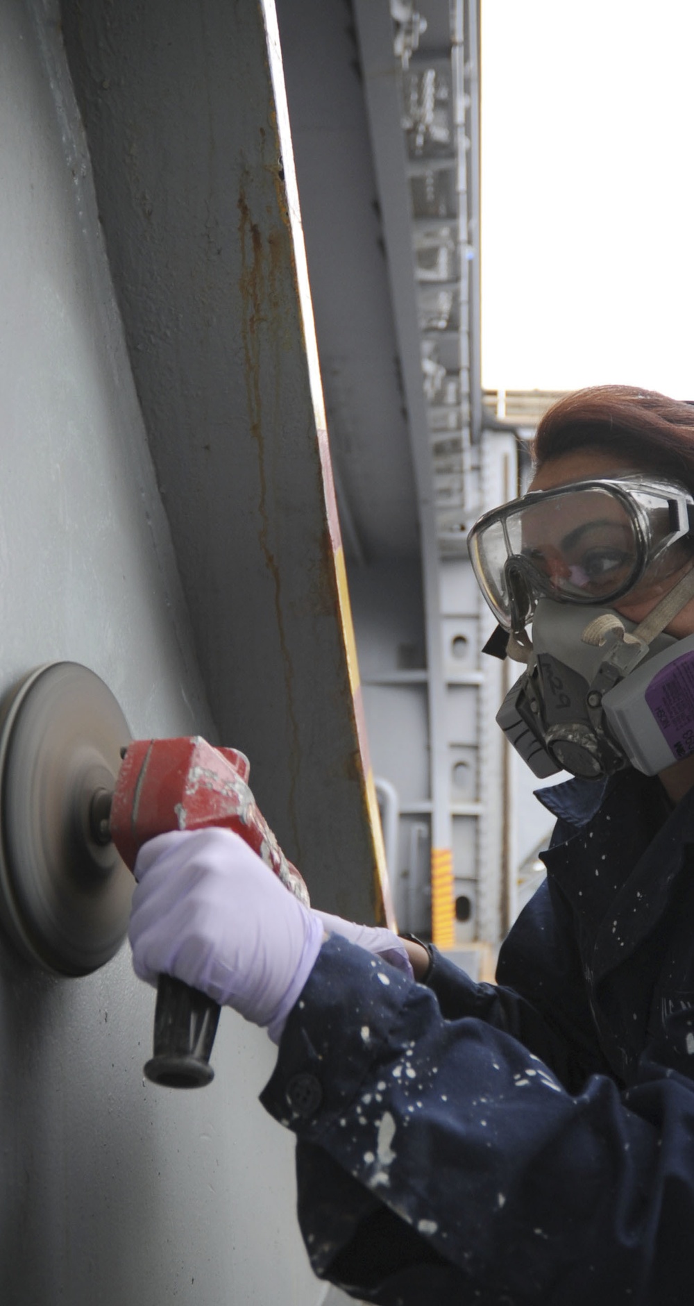 Sailor prepares to paint by sanding