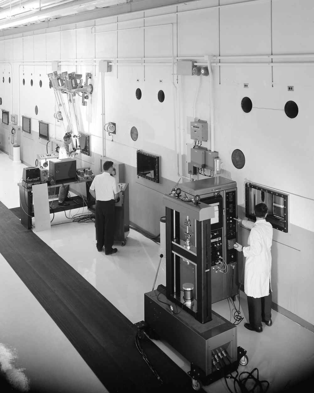 COLD SIDE OF HOT LAB ROOM NO. 8 SHOWING OPERATORS AT CONTROL RESEARCH MANIPULATORS INSTRON TENSILE AND GENERAL MILLS EQUIPMENT AT NASA PLUM BROOK STATION