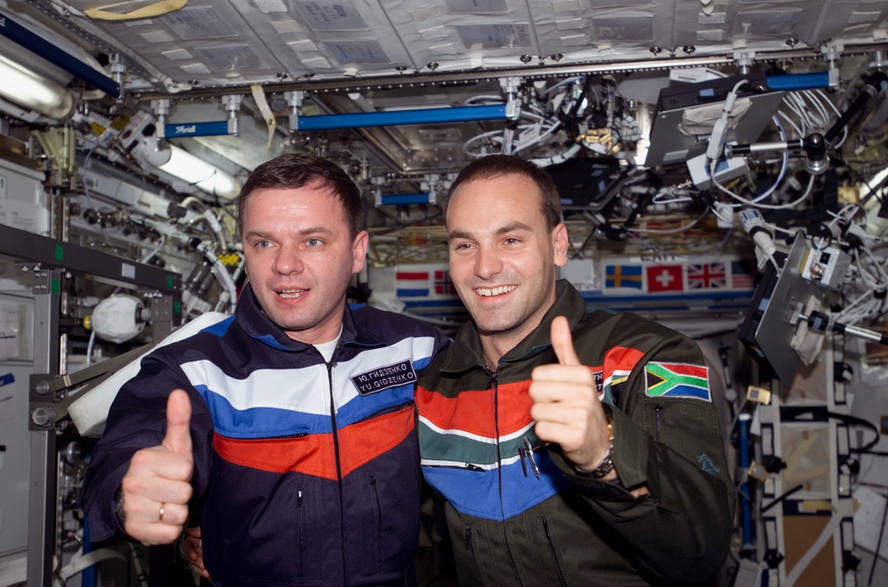 Gidzenko and Shuttleworth thumbs up photo in U.S. Lab during Expedition Four