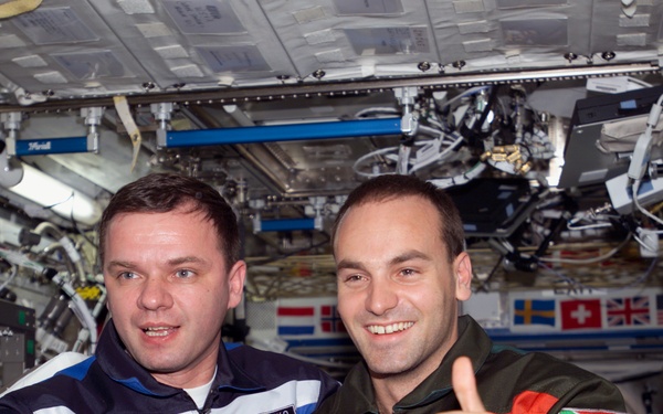 Gidzenko and Shuttleworth thumbs up photo in U.S. Lab during Expedition Four