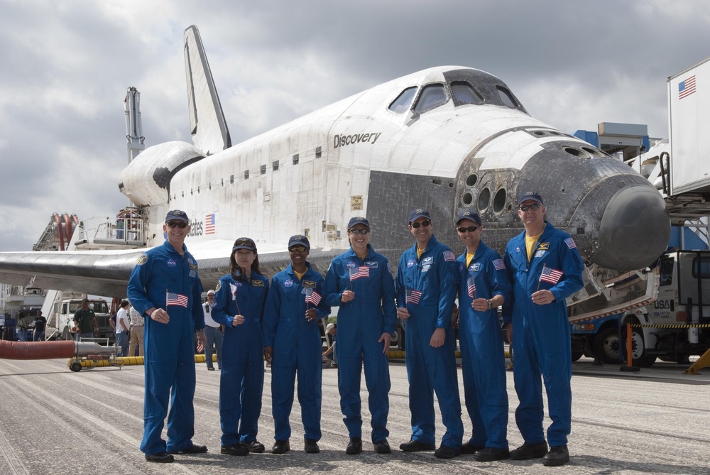 STS-131 Crew Wave Their Flags