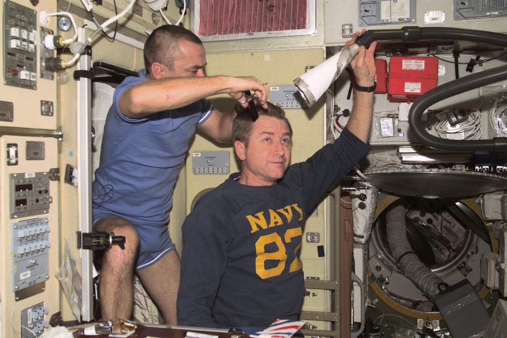 Tyurin gives Culbertson a haircut in the Service Module during Expedition Three