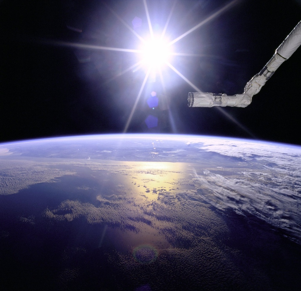 Robot Arm Over Earth with Sunburst