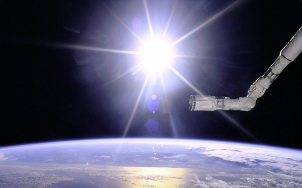 Robot Arm Over Earth with Sunburst