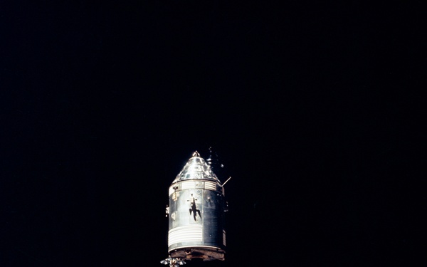Apollo 14 Mission image - The Apollo Command and Service Modules CSM are photographed against a black sky background from the Lunar Module LM above the Moon.