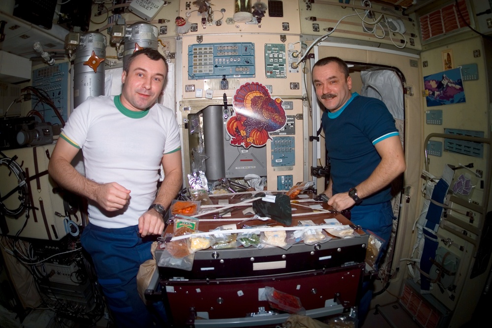 Tyurin and Dezhurov eat a Thanksgiving meal in Zvezda during Expedition Three
