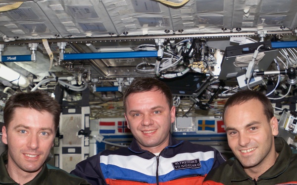 Soyuz 4 taxi-3 flight crew poses for group photo in U.S. Lab during Expedition Four