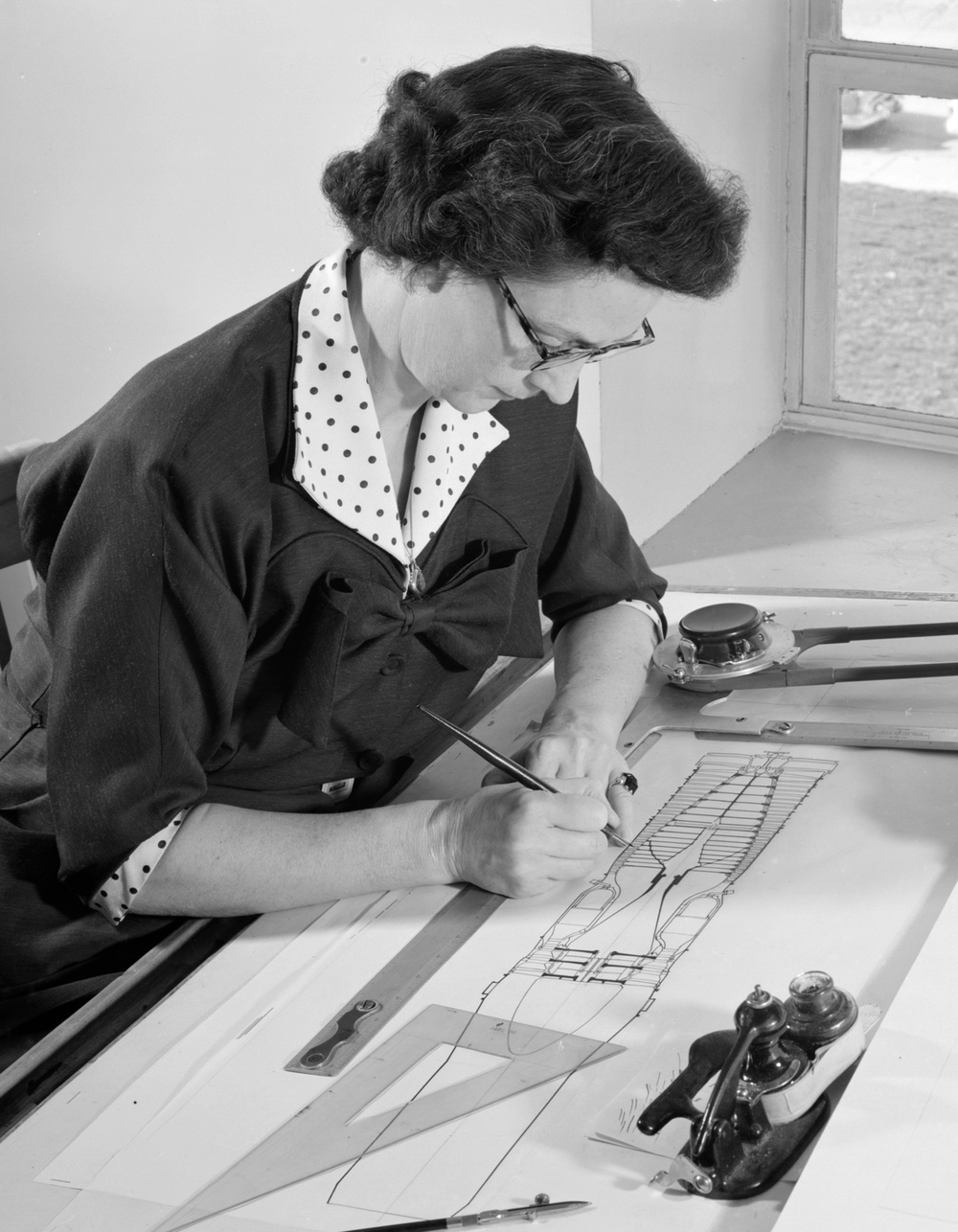 ILLUSTRATOR DOROTHY WHIDDEN AT THE DRAWING BOARD WITH REPORT ILLUSTRATION