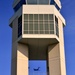 C-17 Globemaster III is framed by the Dover Air Force Base Air Traffic Control Tower