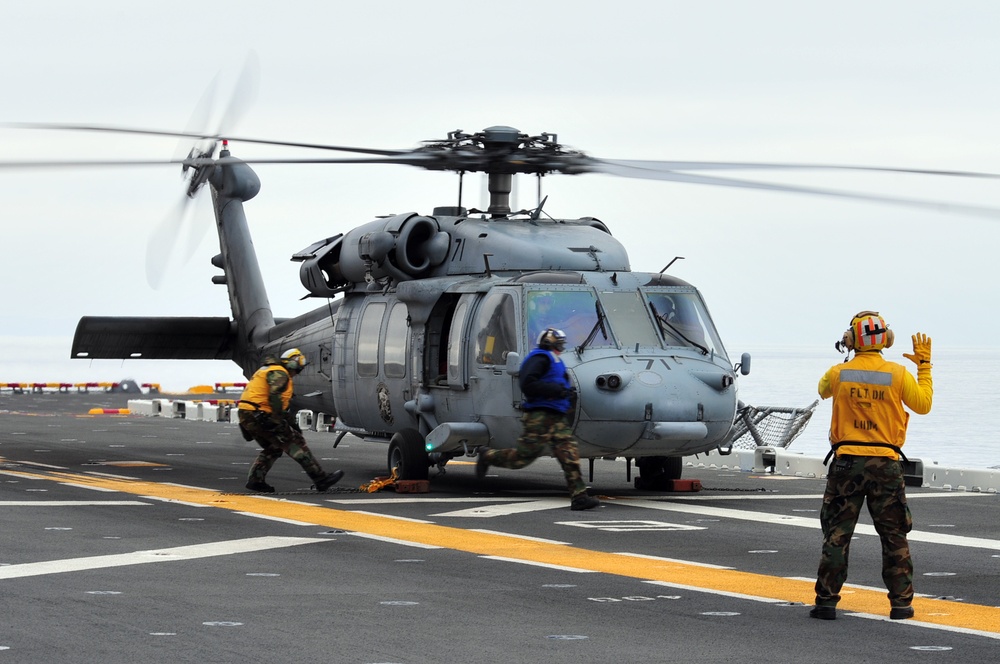 Signaling an MH-60S Sea Hawk helicopter