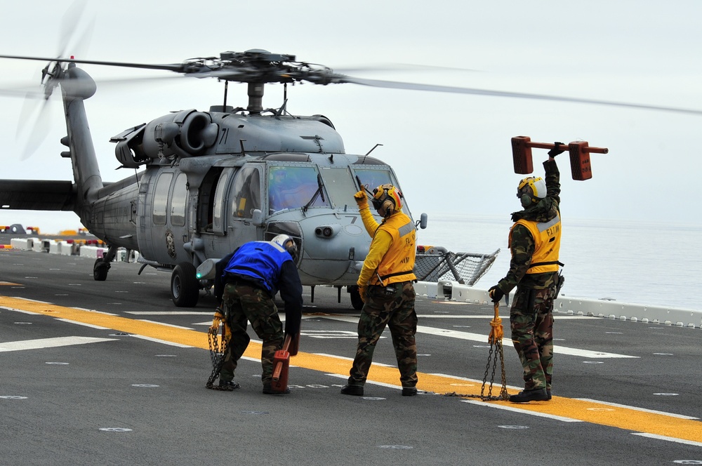 Signaling an MH-60S Sea Hawk helicopter