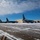 108th Wing removes snow from winter storm Nemo Multiple large military aircraft are parked on a snow-covered tarmac at what appears to be a military air base. The aircraft, consistent in appearance with KC-135 Stratotanker refueling jets, are lined up in a row alongside a large hangar building. Winter conditions are evident with snow and ice covering the ground surface.