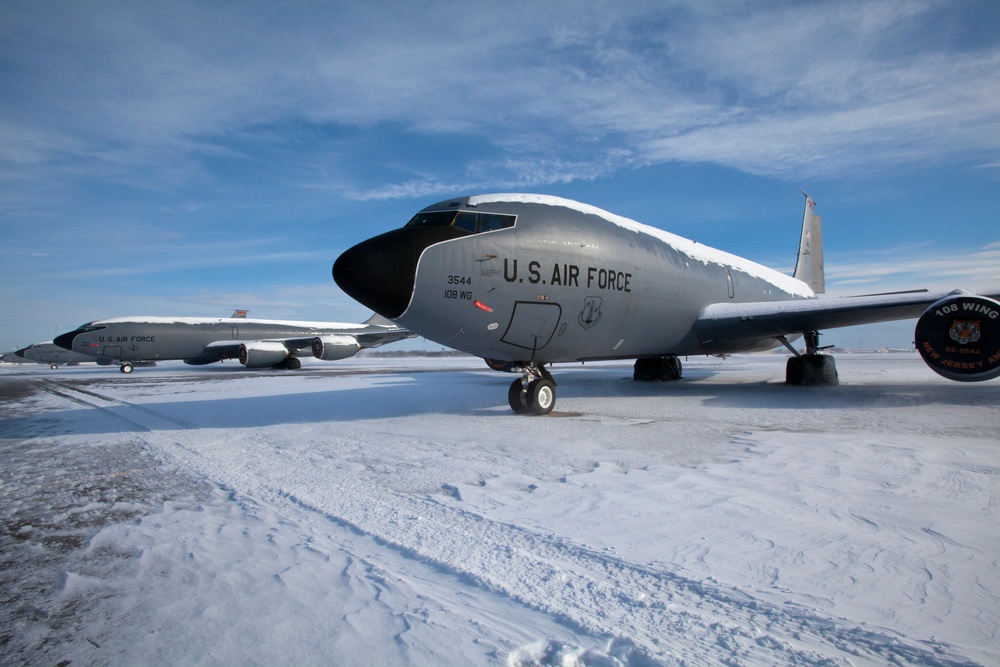 Two U.S. Air Force KC-135 Stratotanker aircraft are parked on a snow-covered flight line, assigned to the 108th Wing, New Jersey Air National Guard. The foreground aircraft bears tail number 3544 and displays '108 WG' and 'New Jersey' markings on its engine nacelle. The scene depicts winter conditions with snow accumulated on the aircraft fuselages and tarmac.