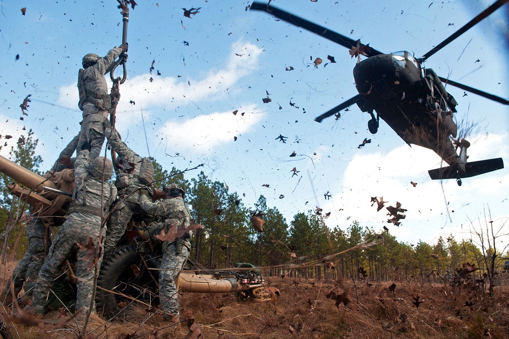 Soldiers prepare to hook up howitzer