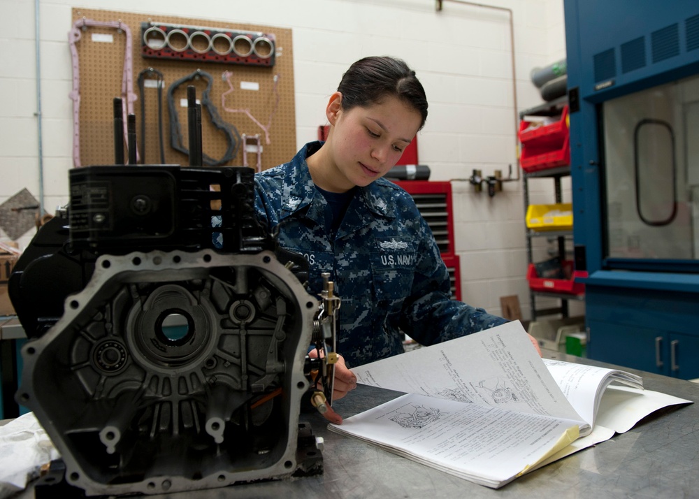 Sailor reads how to reassemble a fire pump