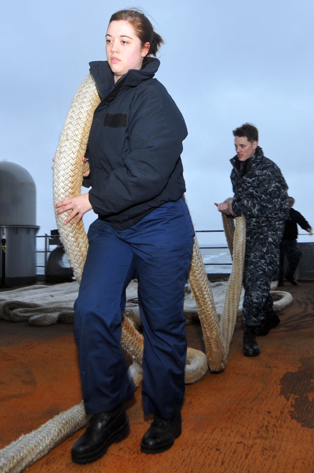 Sailors heave in mooring lines