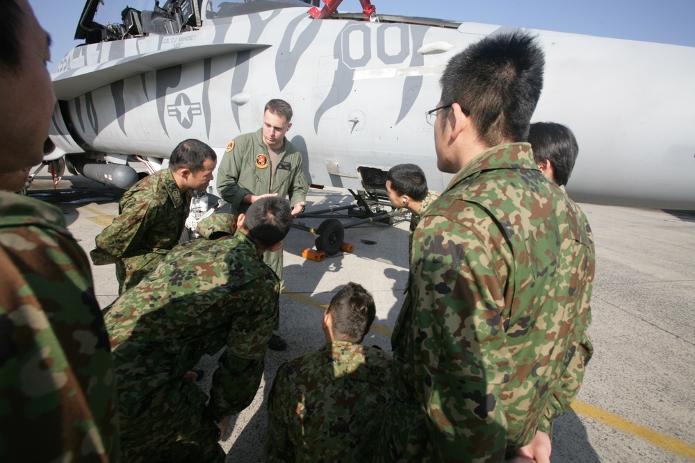 Capt. Sean Roberts, a FA-18/D Hornet pilot with Marine All Weather Fighter Attack Squadron 224, points out different parts of a FA-18/D to members of the Japan Ground Self Defense Force during a recent visit to Marine