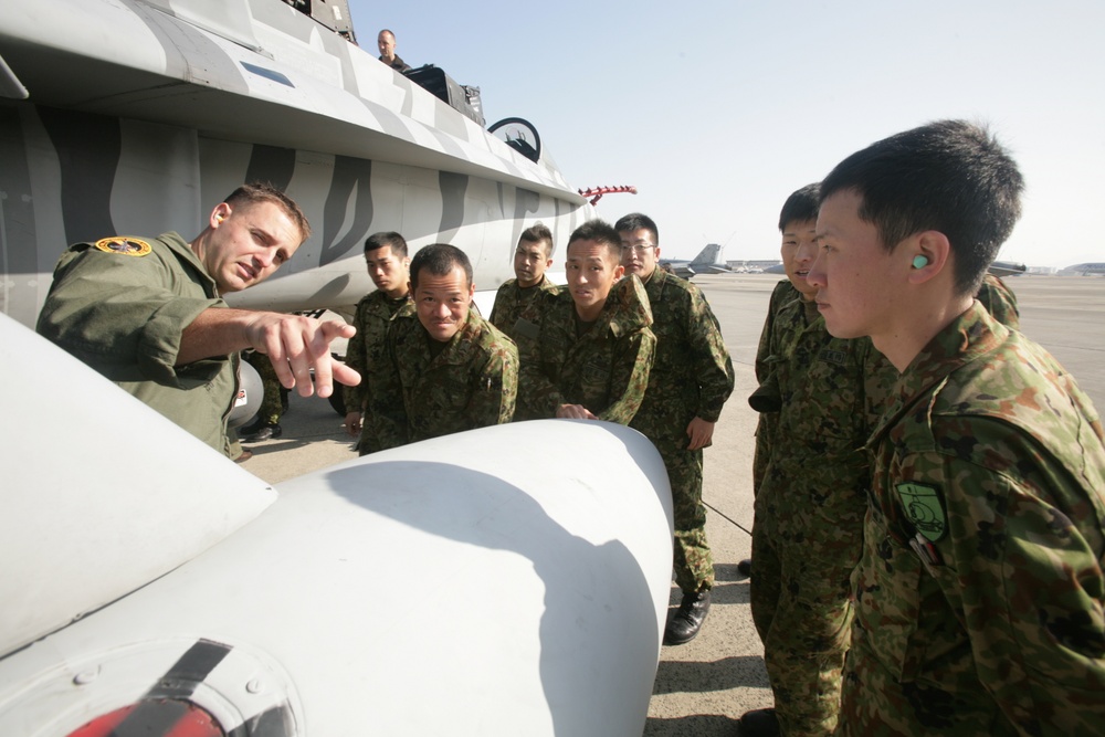 Capt. Sean Roberts, a FA-18/D Hornet pilot with Marine All Weather Fighter Attack Squadron 224, points out different parts of a FA-18/D to members of the Japan Ground Self Defense Force during a recent visit to Marine