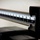 The image shows a close-up of a mechanical beam balance scale, commonly found in medical or clinical settings. Two measurement beams are visible — an upper beam showing larger weight increments (around 28–32 lbs range visible) and a lower beam showing finer increments (around 12–14 range visible). The scale is black metal with white measurement markings, photographed with a shallow depth of field.