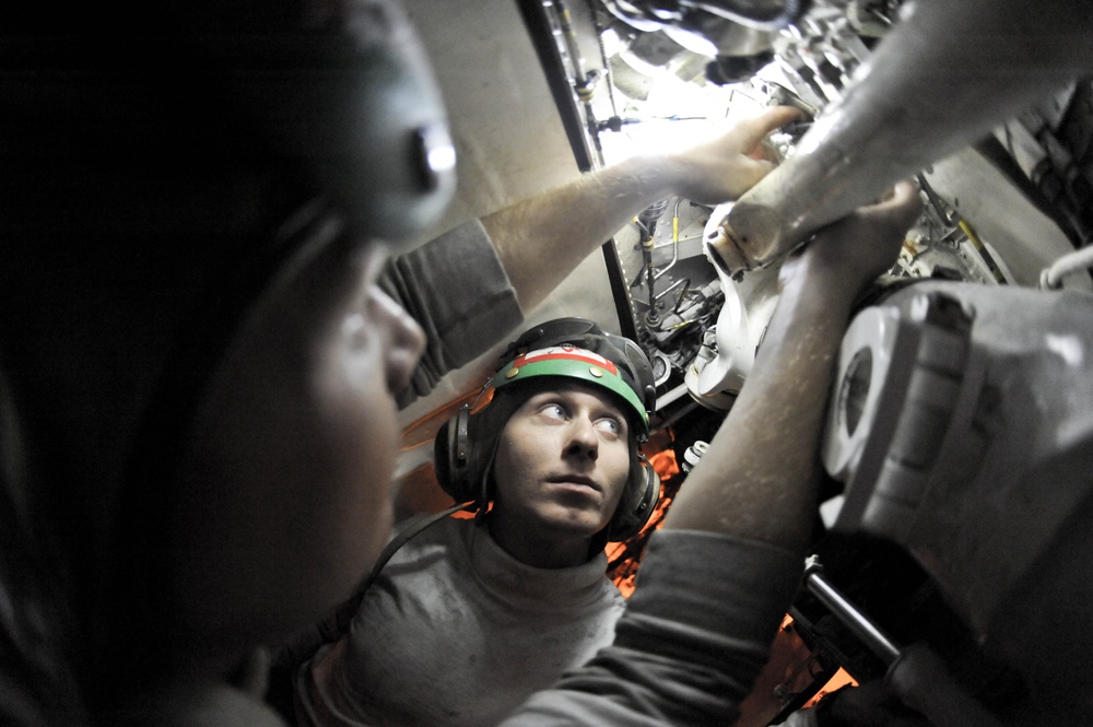 USS Nimitz sailors at work in hangar bay