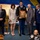 Hawaii State Medal of Honor ceremony pays tribute to fallen service members A formal military award ceremony is taking place indoors, likely in a government or ceremonial hall. A U.S. Army soldier in dress uniform is presenting a framed medal or citation to a civilian man, surrounded by other dignitaries including a U.S. Air Force officer and civilian officials. The atmosphere is solemn, with participants bowing their heads in a moment of reverence.