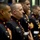 Hawaii State Medal of Honor ceremony pays tribute to fallen service members A group of United States Marines are standing in formation wearing their dress blue uniforms. The Marines are aligned in a row, facing the same direction, suggesting a formal ceremony or official event. The foreground Marine displays service ribbons and medals on his chest.