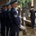 Hawaii State Medal of Honor ceremony pays tribute to fallen service members A military funeral or memorial ceremony is taking place at what appears to be a government or memorial building. An Army soldier in dress blues plays a bugle (likely 'Taps') while an Air Force honor guard stands at attention in the foreground holding rifles. Additional soldiers in ACU (Army Combat Uniform) camouflage are visible rendering salutes in the background.