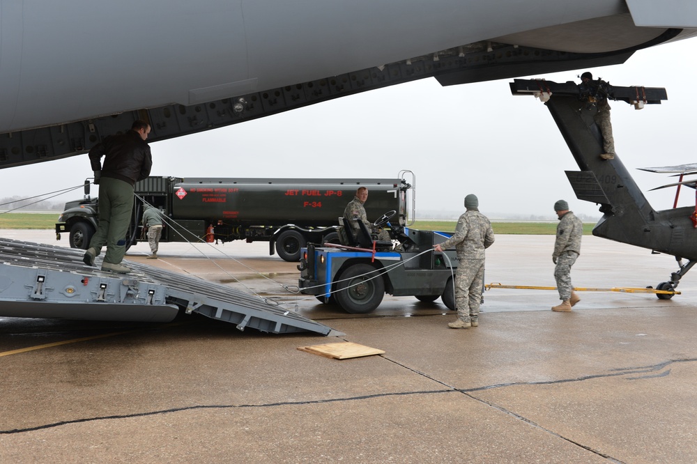 Army, Air National Guard members load HC-60 Black Hawk on board a C-17