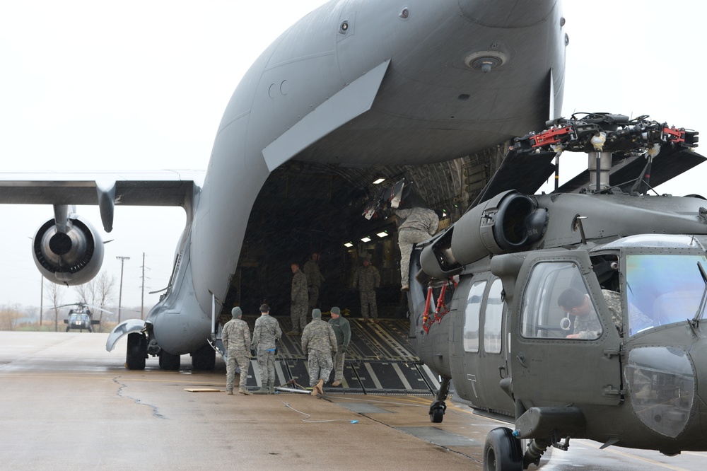 Army, Air National Guard members load HC-60 Black Hawk on board a C-17