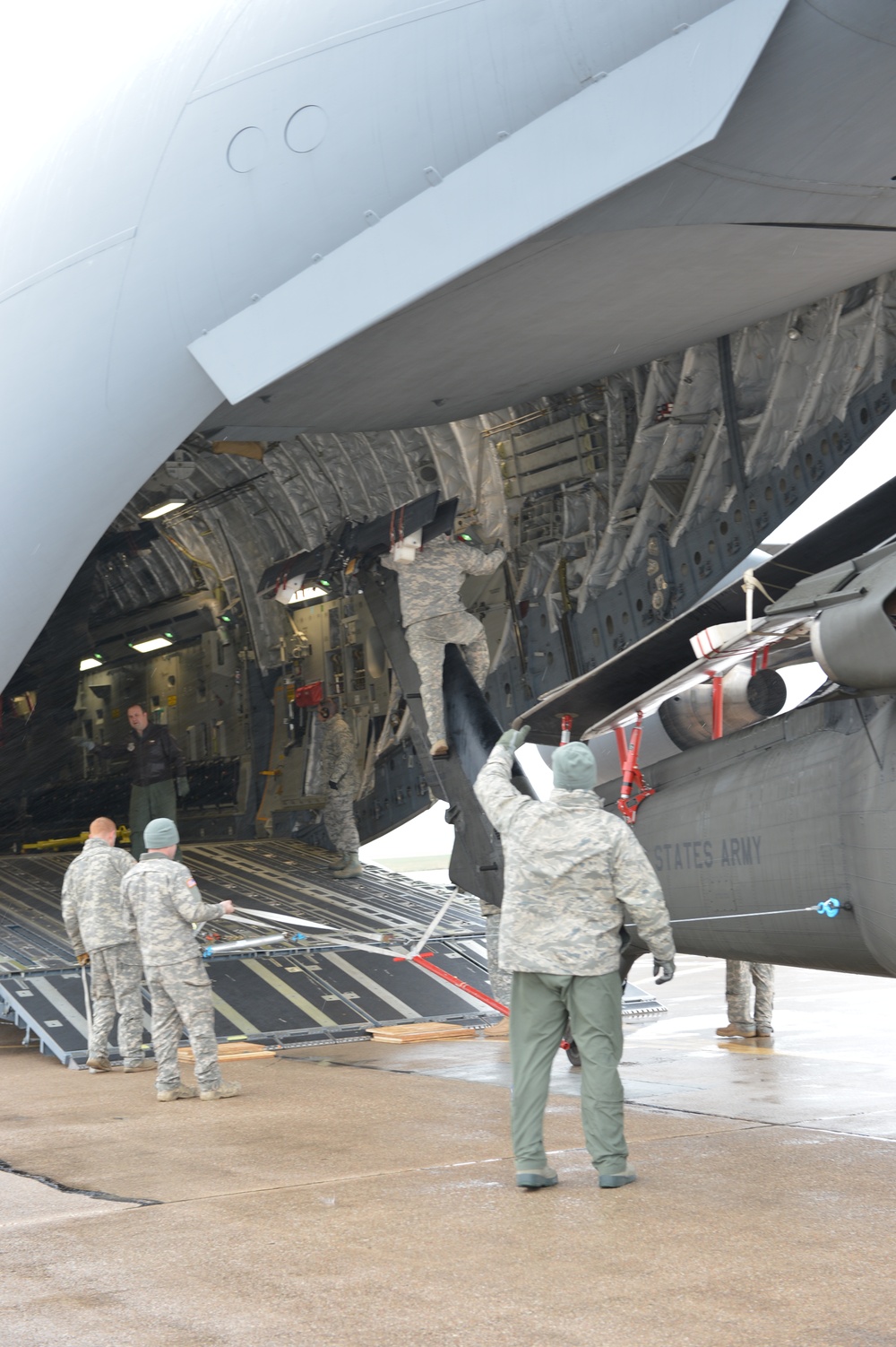 Army and Air National Guard members loading HC-60 Black Hawk on board a C-17