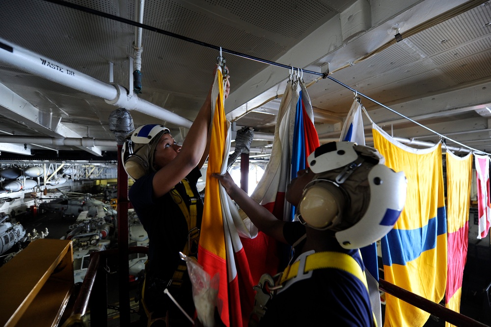 USS John C. Stennis sailor hangs flags