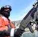 A Coast Guard Station crew member mans the gun mount in the Boston Harbor