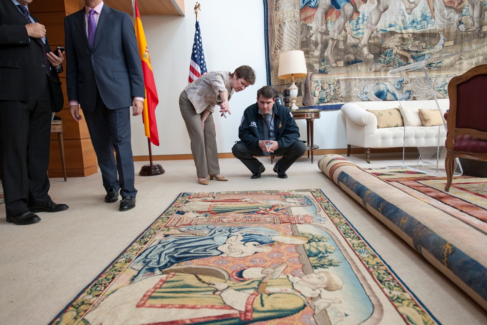 ICE personnel inspecting the tapestry