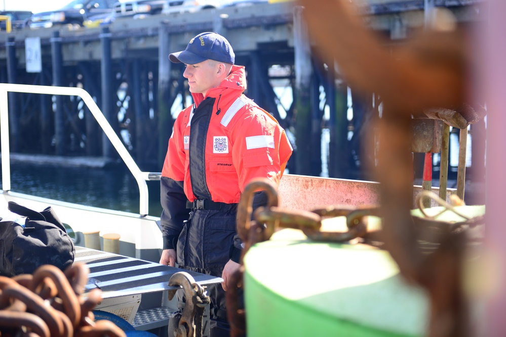 A Coast Guard crew member prepares to go underway in the Boston Harbor