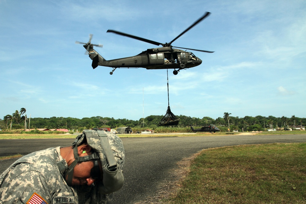 Troops endure strong winds during sling load training in Panama