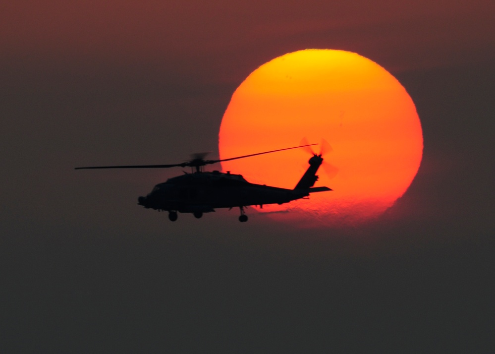 HH-60H Sea Hawk flies at sunset