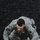 Best Warrior Competition A U.S. Army soldier in Army Combat Uniform (ACU) digital camouflage pattern is crawling or climbing over a low barrier or surface marked with yellow paint lines. The soldier is wearing a U.S. flag patch and an additional unit patch on the left sleeve, suggesting active duty service. The activity appears to be part of a physical training exercise or obstacle course.
