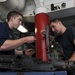 USS Dwight D. Eisenhower sailors perform maintenance on machine gun