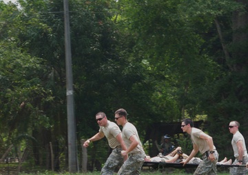 The ground medic team rushes the casualty into the UH-60 Black Hawk for a mock medevac scenario during a training exercise