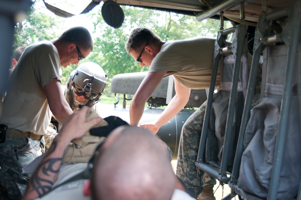 The ground medic team loads the casualty into the UH-60 Black Hawk for a mock medevac scenario during a training exercise