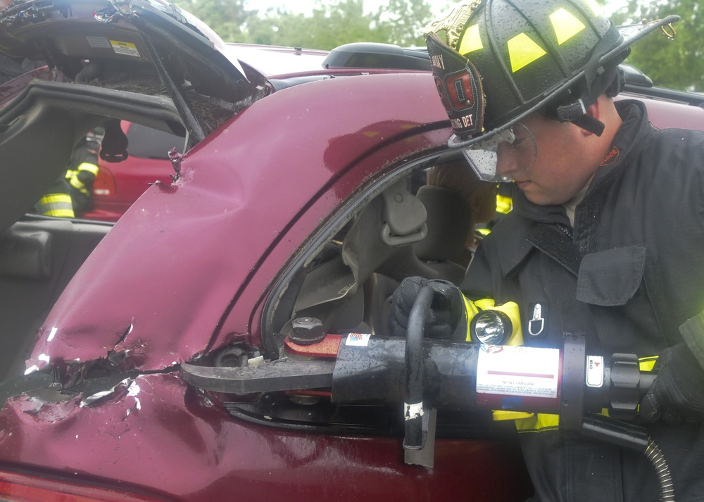 National Guard firefighters learn to rescue victims of auto accidents at local car parts lot