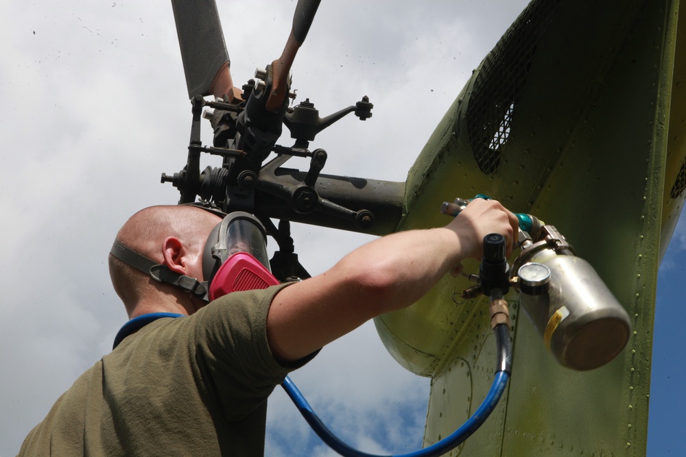 Marines from Marine Aviation Logistics Squadron 29 spray primer paint on a UH-34 from the aviation memorial aboard Marine Corps Air Station New River, May 21. The painting is part of an effort to restore a part of Marine Corps history.