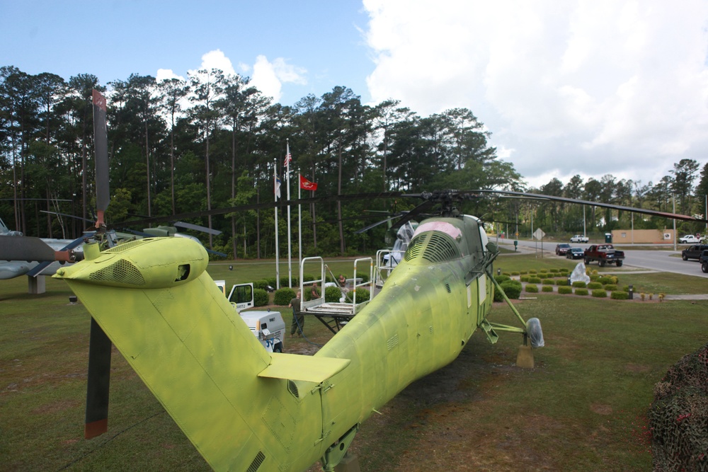 Marines from Marine Aviation Logistics Squadron 29 spray primer paint on a UH-34 from the aviation memorial aboard Marine Corps Air Station New River, May 21. The painting is part of an effort to restore a part of Marine Corps history.