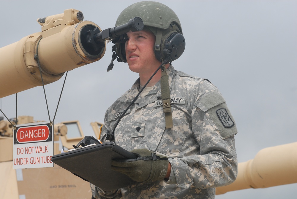 Spc. Corey M. Locker bore sights the main weapon system of an M1A1 Abrams tank