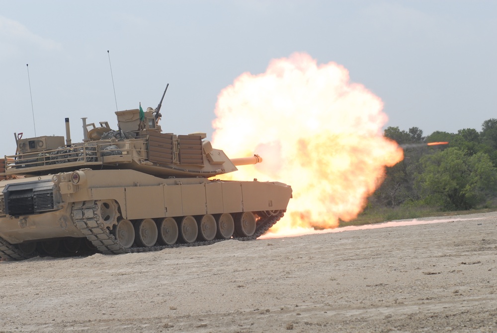 Soldiers from Delta Company, 1-145th Armored Regiment, fire rounds down range from an M1A1 Abrams tank